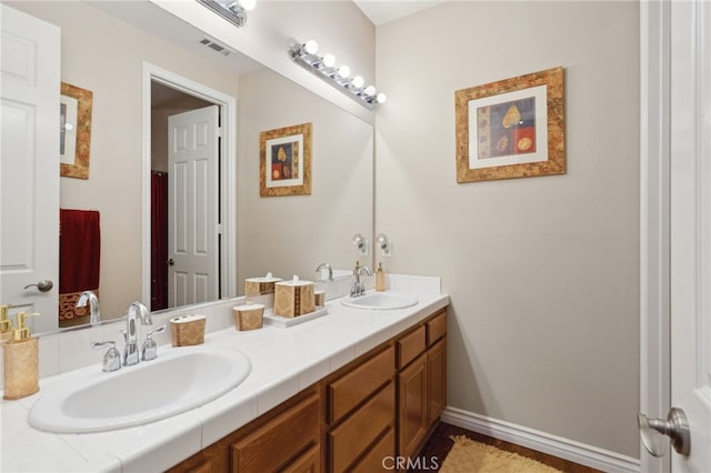 full bathroom with a sink, double vanity, and visible vents