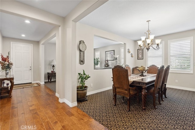 dining space featuring recessed lighting, baseboards, an inviting chandelier, and wood finished floors