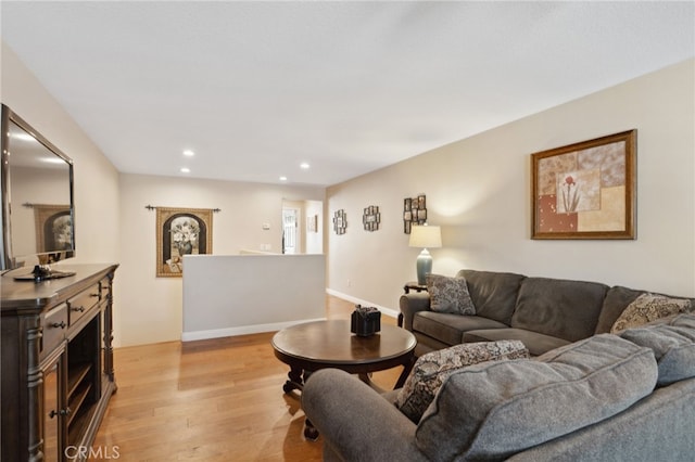 living area with baseboards, recessed lighting, and light wood-style flooring