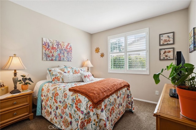 bedroom with baseboards and dark carpet