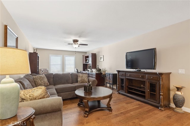 living area with a ceiling fan and wood finished floors