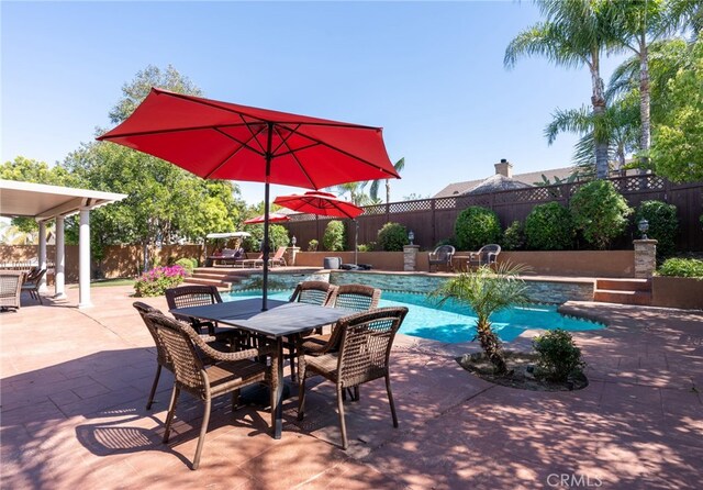 view of pool featuring a fenced in pool, outdoor dining space, and a fenced backyard