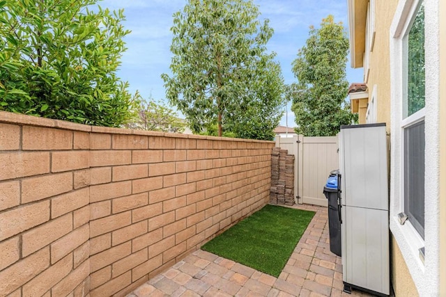 view of patio featuring fence and a gate