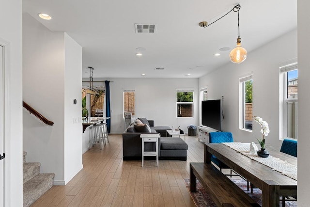 living area with recessed lighting, visible vents, stairway, and light wood-style floors