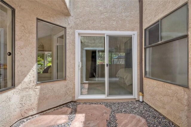 entrance to property featuring stucco siding
