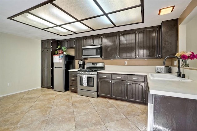 7553 Agua Dulce Ct, Carlsbad, CA 92009 - kitchen with stainless steel appliances, dark brown cabinets, light countertops, and light tile patterned flooring