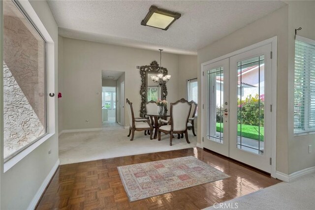 doorway to outside featuring a textured ceiling, a healthy amount of sunlight, and french doors