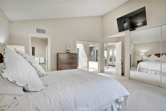 bedroom with visible vents, carpet flooring, a textured ceiling, and high vaulted ceiling