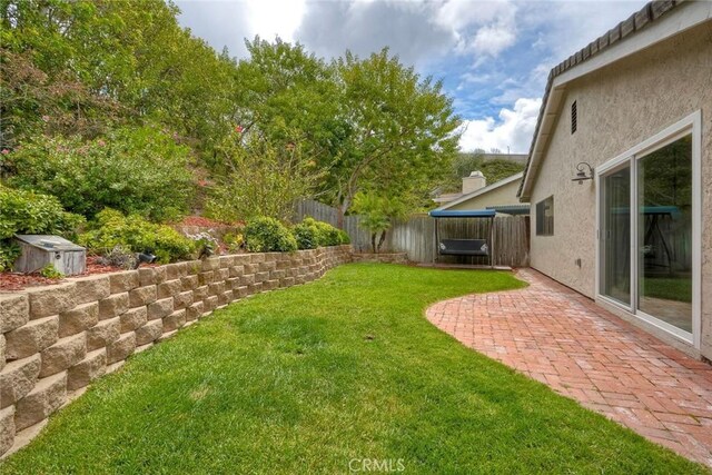 view of yard with a fenced backyard, an outbuilding, a patio area, and a shed