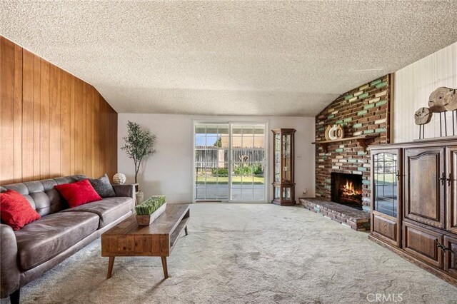 living area featuring wood walls, carpet, a textured ceiling, and vaulted ceiling