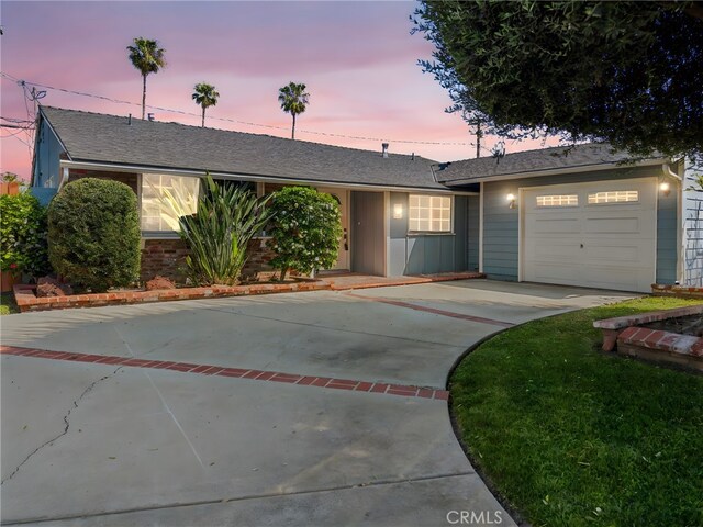 single story home featuring a garage, a shingled roof, and concrete driveway