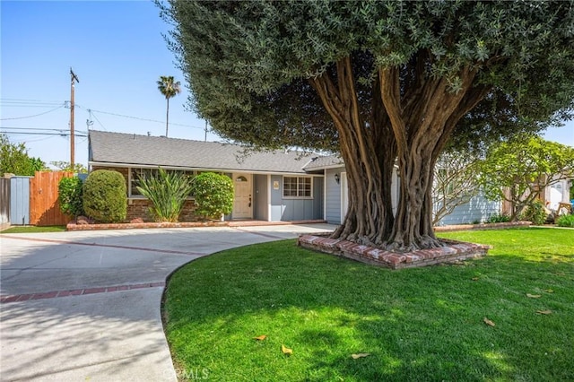 ranch-style home with fence, driveway, and a front yard