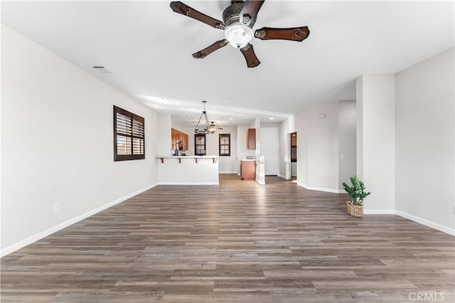 unfurnished living room featuring visible vents, wood finished floors, baseboards, recessed lighting, and ceiling fan with notable chandelier