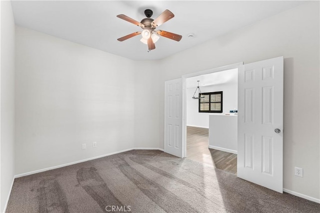 carpeted empty room with baseboards and ceiling fan