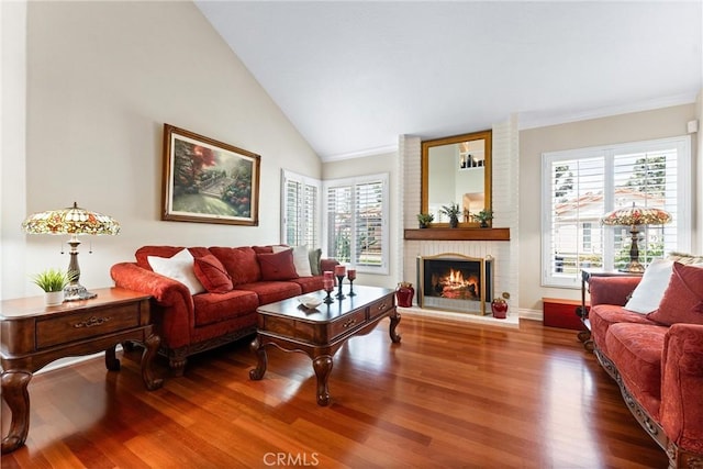 living room with baseboards, wood finished floors, vaulted ceiling, and a fireplace