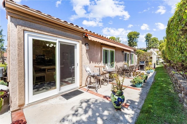 back of property featuring a patio area and stucco siding