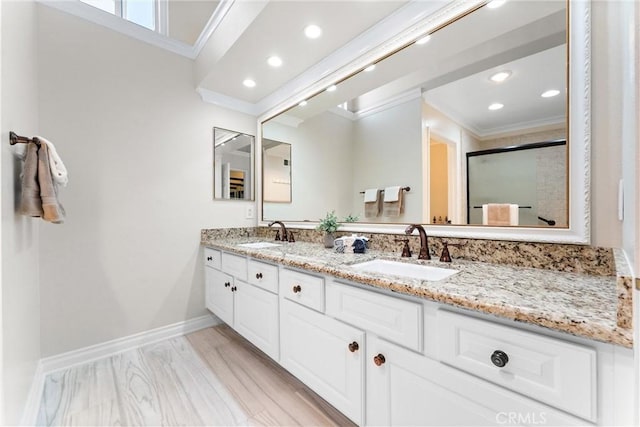 full bath featuring ornamental molding, a sink, and a shower stall