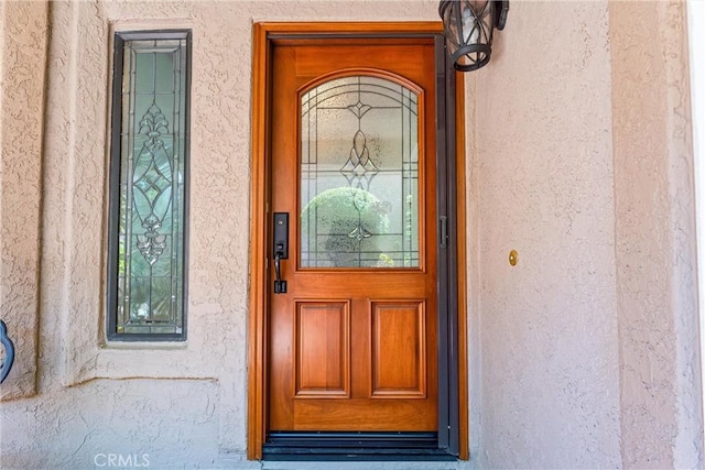 view of exterior entry featuring stucco siding