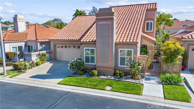 mediterranean / spanish-style house with a garage, stucco siding, a chimney, a tiled roof, and concrete driveway