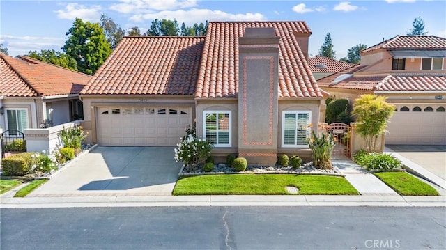 mediterranean / spanish-style house featuring concrete driveway, an attached garage, a tile roof, and stucco siding