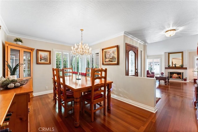 dining area featuring a textured ceiling, a brick fireplace, baseboards, a chandelier, and dark wood-type flooring