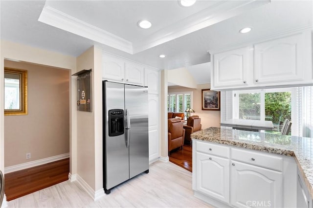 kitchen with white cabinets, light stone countertops, light wood-style flooring, baseboards, and stainless steel refrigerator with ice dispenser