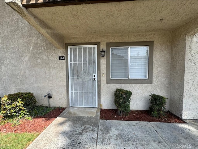 view of exterior entry with stucco siding