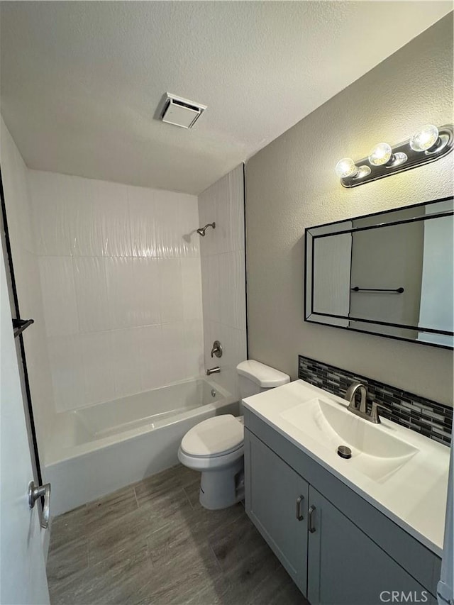 bathroom featuring bathtub / shower combination, vanity, toilet, wood finished floors, and visible vents
