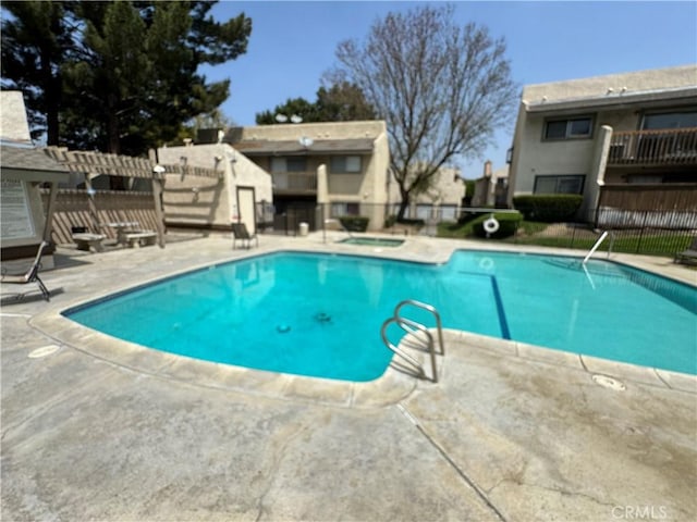 pool featuring a hot tub, fence, and a patio area