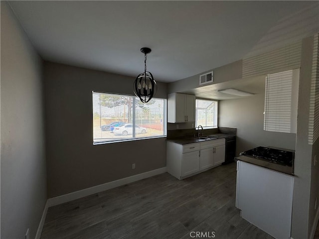 kitchen with dark countertops, a notable chandelier, white cabinetry, baseboards, and visible vents