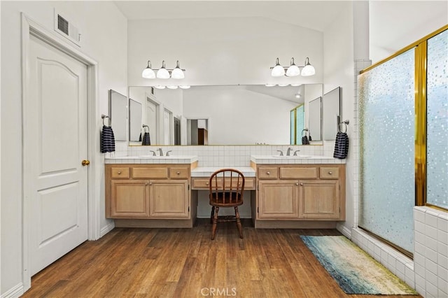 27118 Highlands Ln, Valencia, CA 91354 - bathroom featuring wood finished floors, a shower stall, vanity, backsplash, and vaulted ceiling