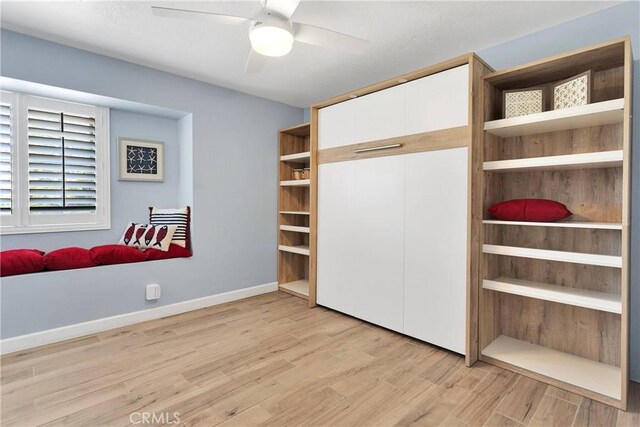 unfurnished bedroom featuring light wood-style floors, baseboards, ceiling fan, and a closet