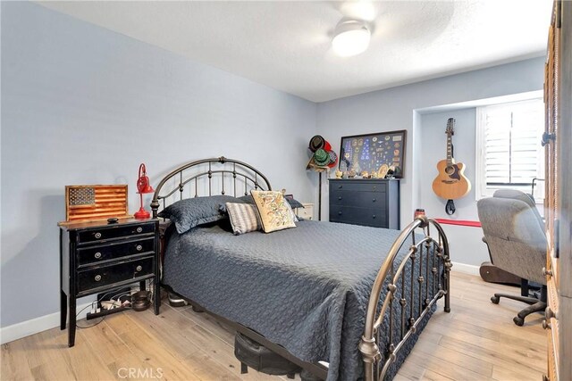 bedroom featuring baseboards, a ceiling fan, and wood finished floors