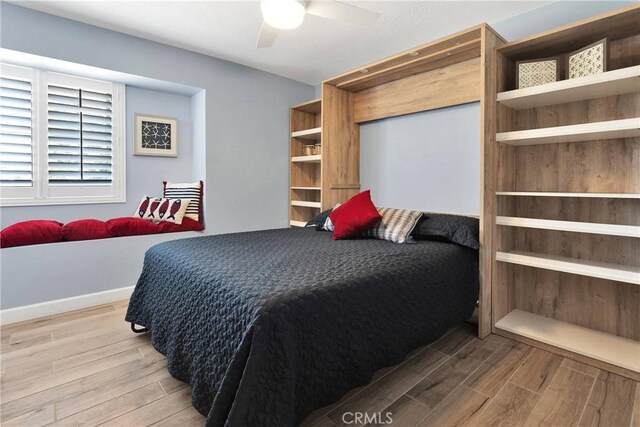 bedroom featuring light wood-style floors, baseboards, and a ceiling fan