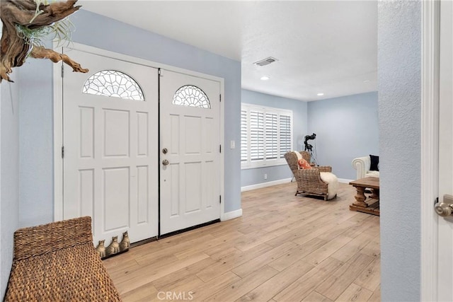 foyer with visible vents, light wood-style flooring, baseboards, and recessed lighting