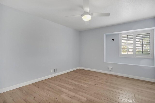 empty room with baseboards, light wood finished floors, and ceiling fan