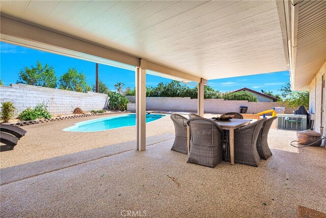 view of swimming pool with a patio, a fenced in pool, a fenced backyard, and outdoor dining space
