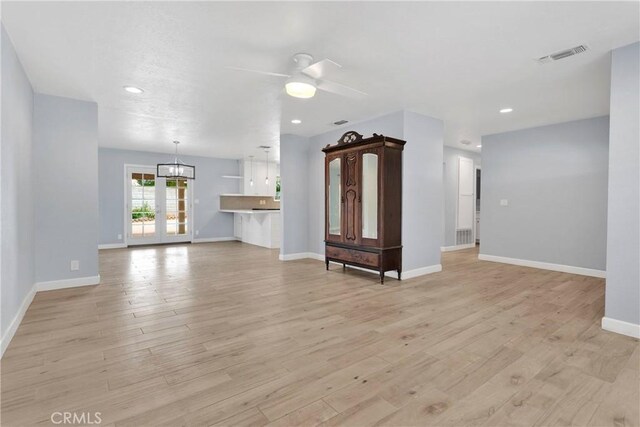 unfurnished living room with ceiling fan, visible vents, baseboards, light wood-style floors, and recessed lighting
