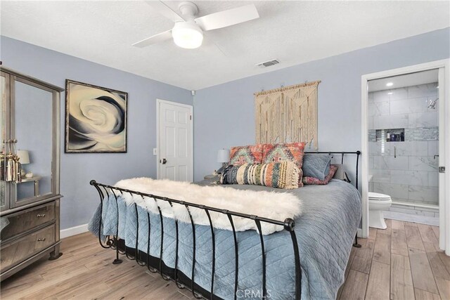 bedroom featuring a ceiling fan, visible vents, baseboards, light wood-style floors, and ensuite bathroom