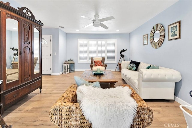 living area featuring a ceiling fan, light wood-style flooring, and a wealth of natural light