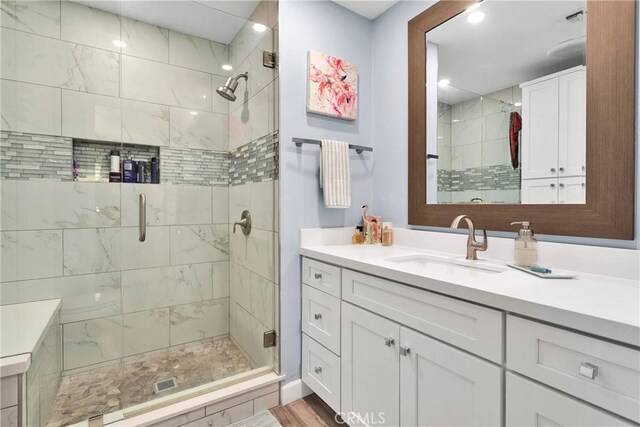 full bathroom featuring vanity, a shower stall, and recessed lighting