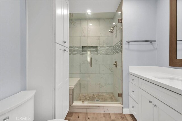 full bath featuring toilet, a shower stall, wood finished floors, and vanity