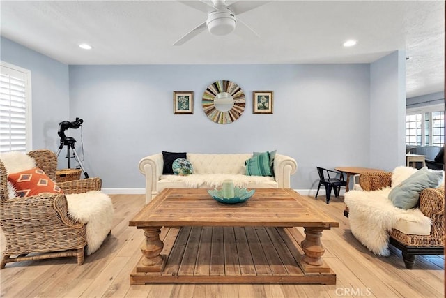 living room featuring a ceiling fan, baseboards, recessed lighting, and light wood finished floors
