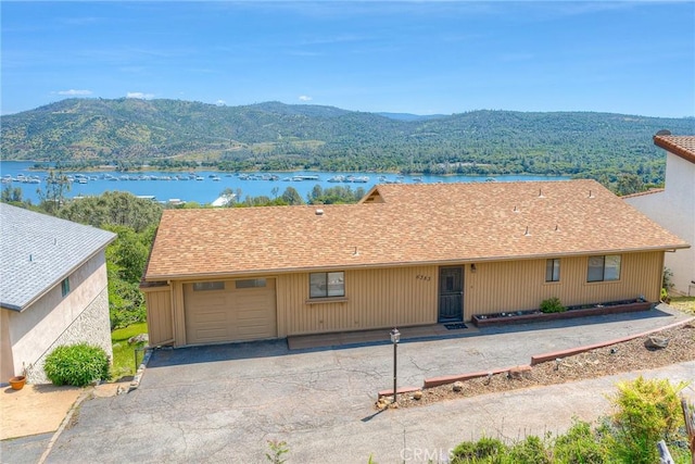 exterior space featuring a garage, a water and mountain view, and aphalt driveway