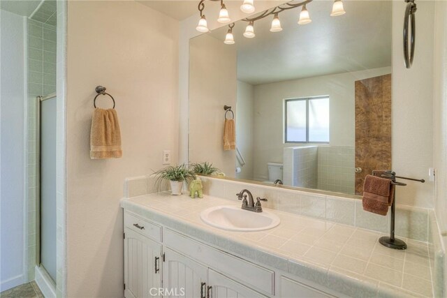 full bathroom with toilet, a shower stall, and vanity
