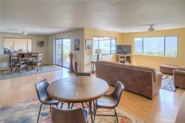 dining space with ceiling fan, plenty of natural light, baseboards, and light wood finished floors