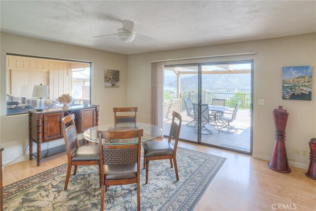 dining space featuring baseboards, a ceiling fan, and light wood-style flooring