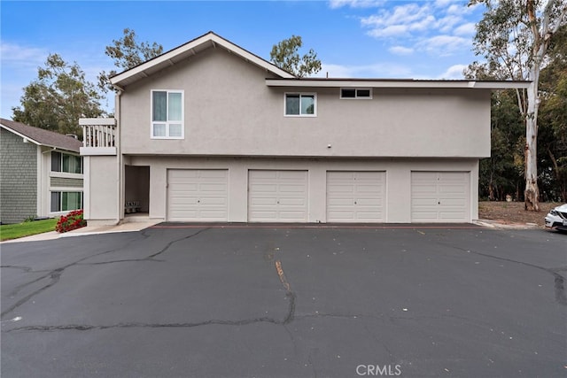 view of front of house featuring a garage, stucco siding, and driveway