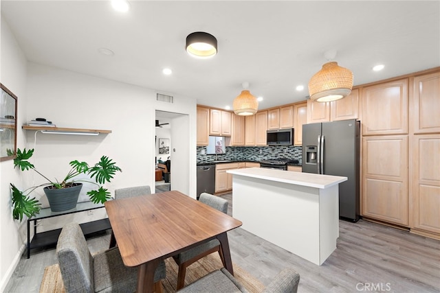 kitchen with light wood finished floors, light brown cabinets, stainless steel appliances, a kitchen island, and visible vents