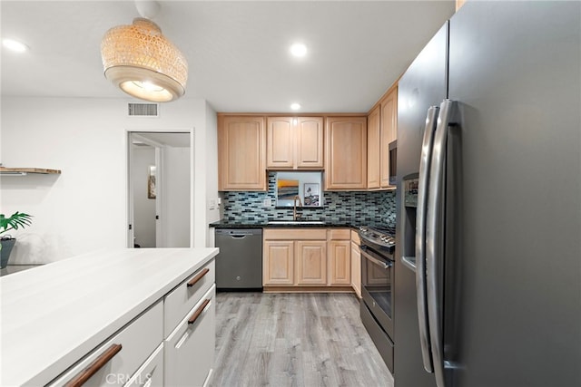 kitchen featuring visible vents, appliances with stainless steel finishes, a sink, light wood finished floors, and light brown cabinets